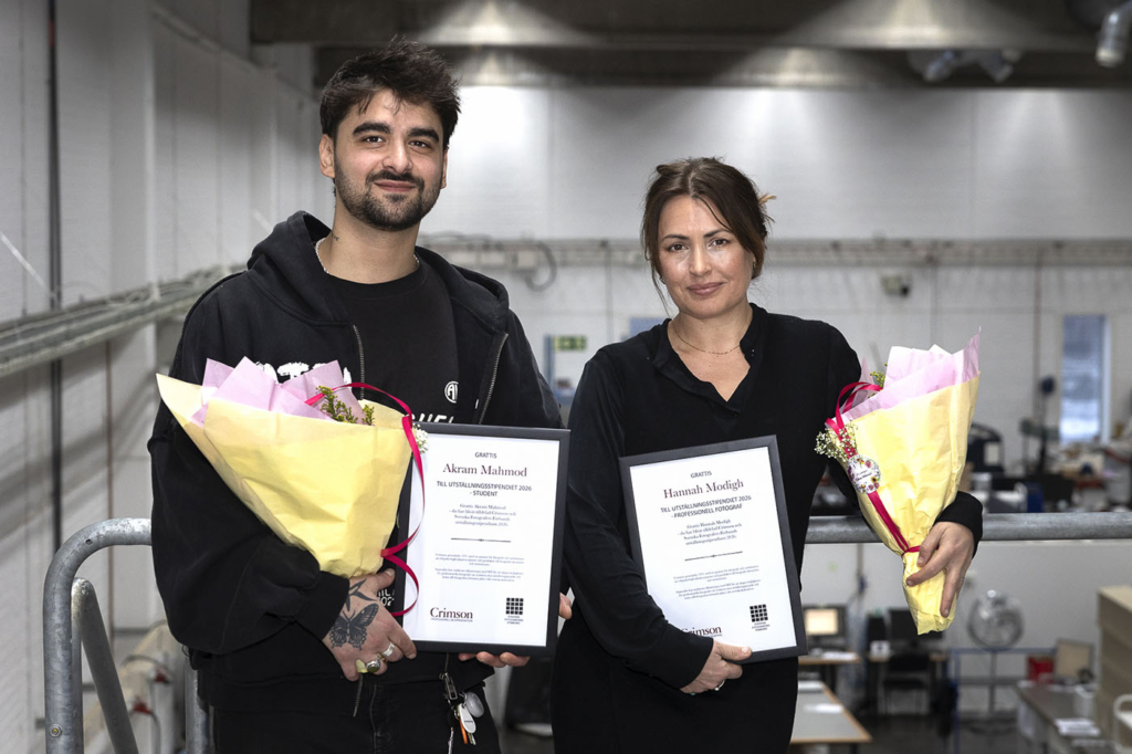 2026 års mottagare av SFF och Crimsons utställningsstipendium: Akram Mahmod och Hannah Modigh. På bilden står de med stipendium och blommor i hand i Crimsons lokaler.
