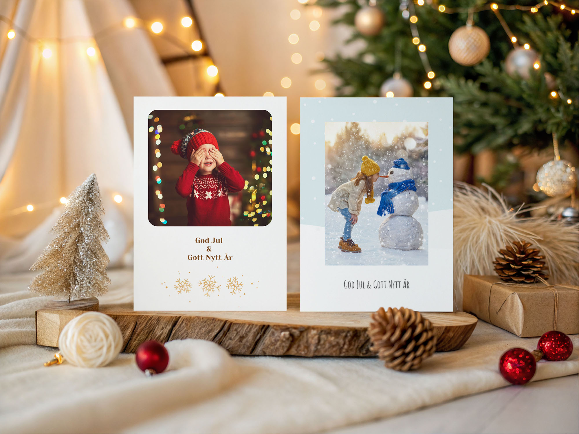 Två julkort med motiv av barn i vintermiljö, upptällda på ett juldekorerat bord.