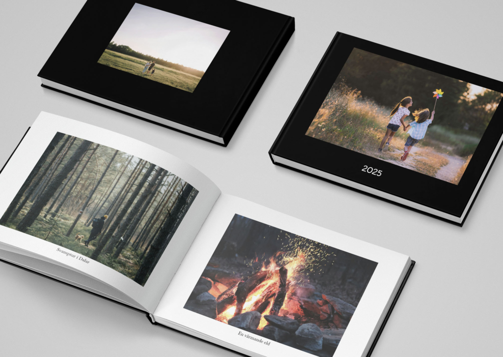 Fotoböcker med svart pärm och omslagsbild föreställande två barn som springer, med texten 2025 under.