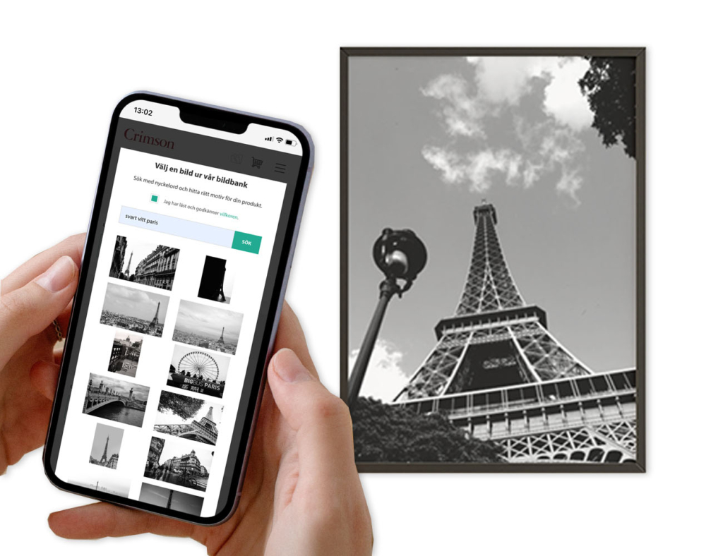 Två händer håller en mobiltelefon där man ser en vy över Crimsons bildbank. I bankgrunden finns en inramad svartvit bild av Eiffeltornet i Paris.