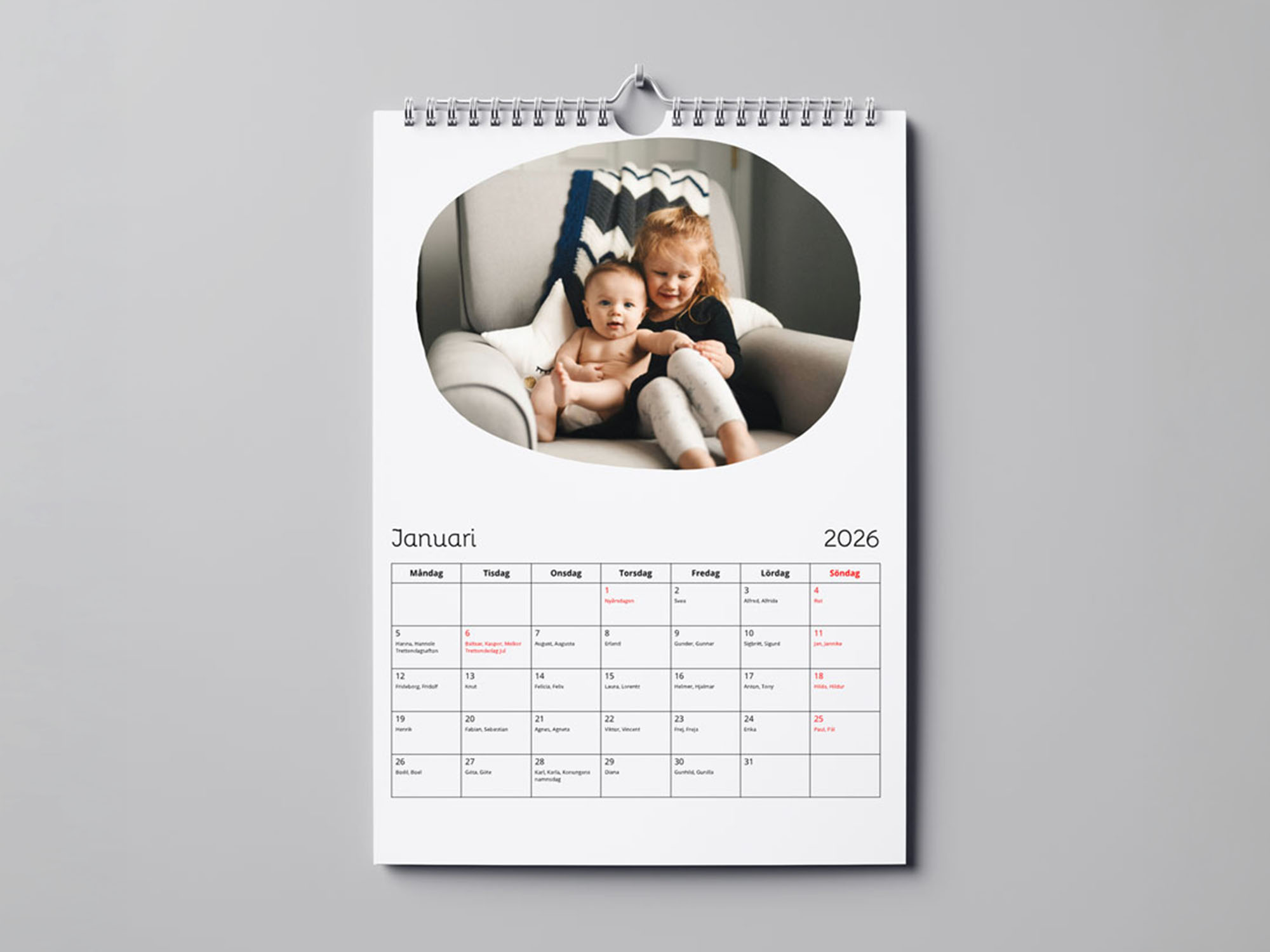 Fotokalender med bildmotiv av två barn sittande i en soffa.