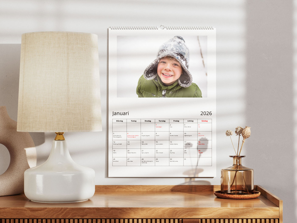 Fotokalender upphängd på vägg ovanför ett sideboard i trä.